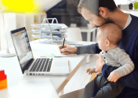 Father holding his baby while working on fathers day