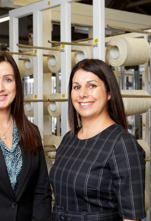 Two women smiling after finding out that Red Diamond partners with heritage textiles firm